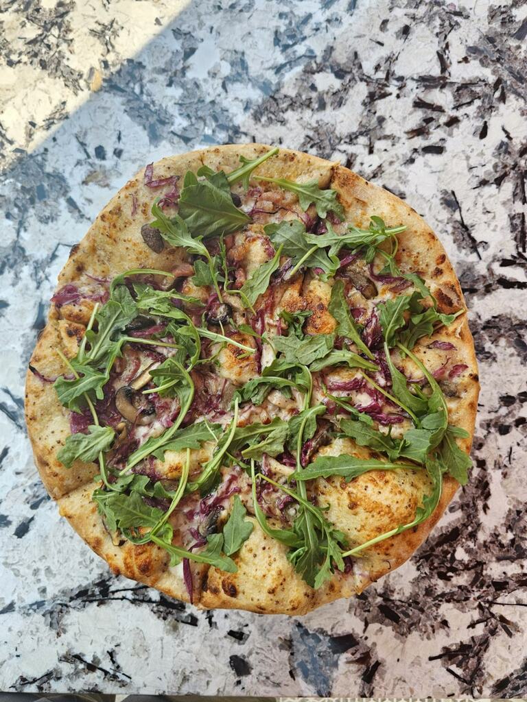 Image depicting a pizza topped with bacon, mushrooms and arugula