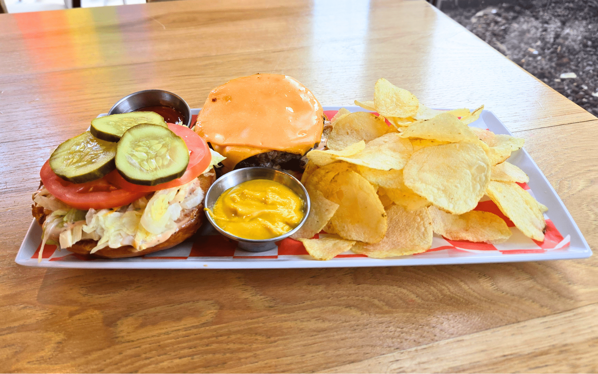 Image depicts a 6 oz smashed patty with American cheese, lettuce, tomato, pickles, and our signature Branch sauce. Served on a toasted bun with your choice of chips or coleslaw.